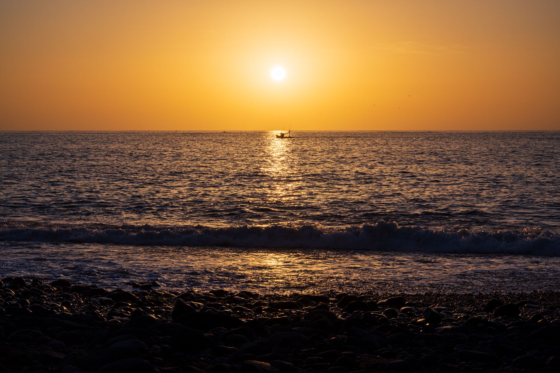 Fischerboot vor untergehender Sonne