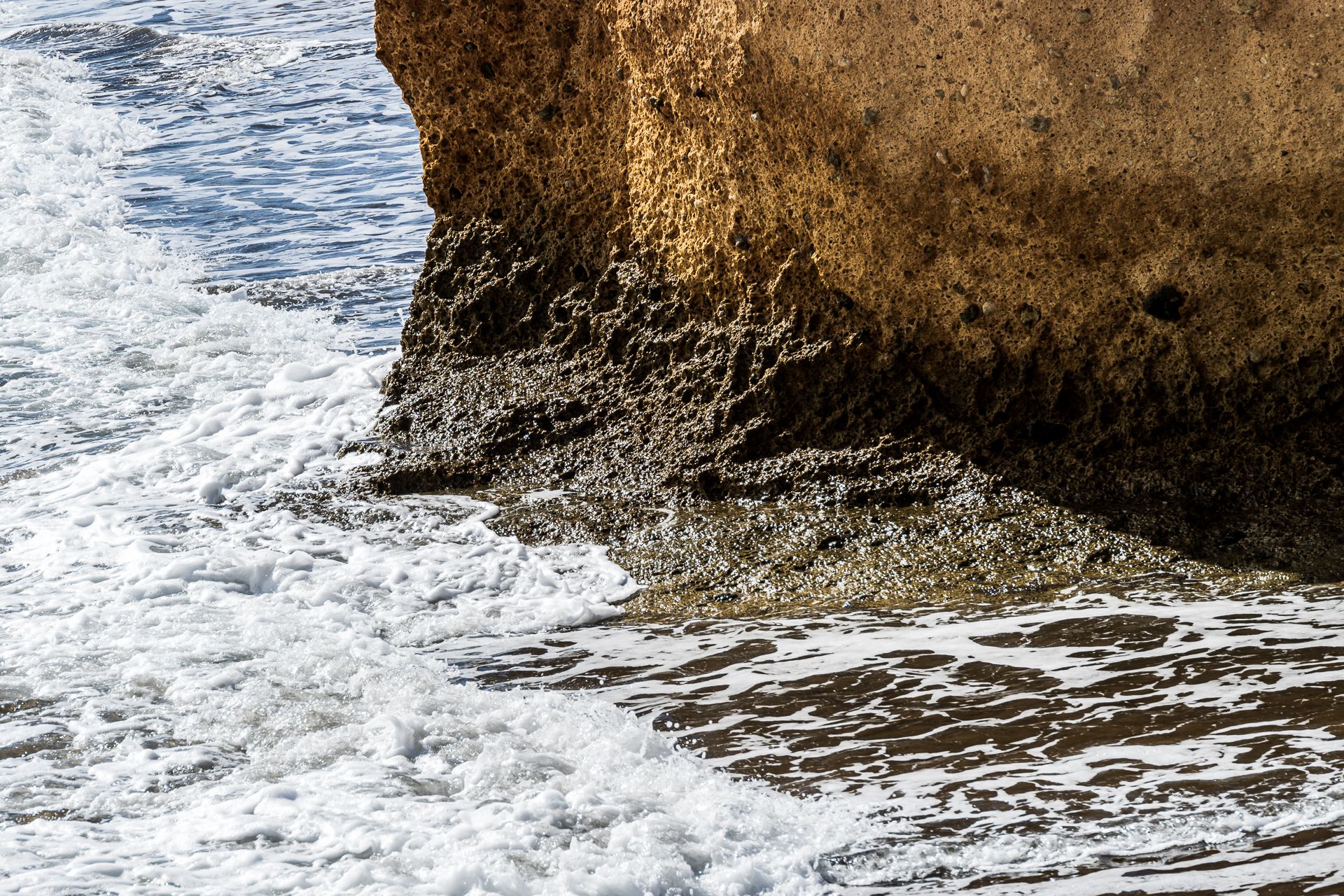 Wasser baut den Sand ab