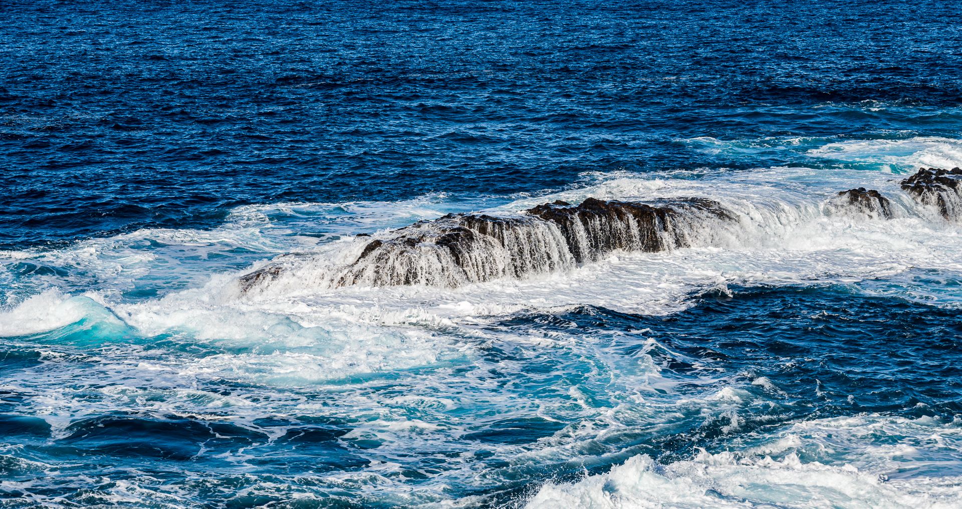 Stein im Wasser wird überspült